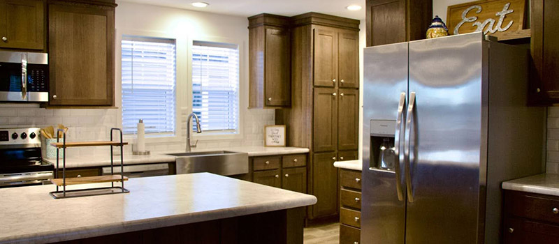 Modern kitchen in Conestoga Gardner Kansas home with stainless steel appliances and wood cabinetry