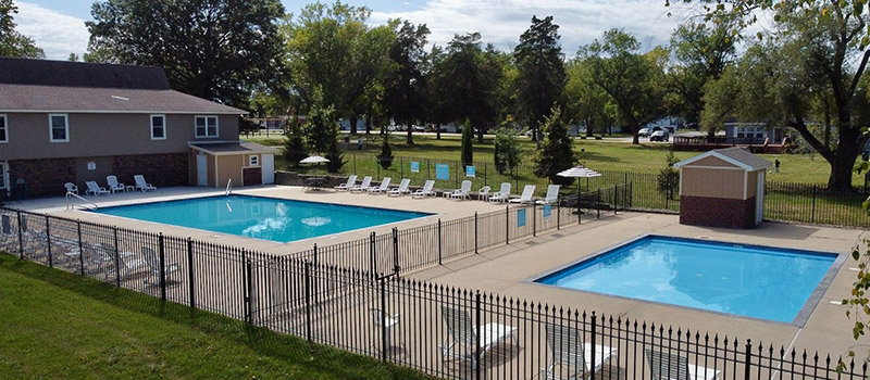 Outdoor swimming pool and clubhouse amenities at Conestoga manufactured home community in Gardner Kansas